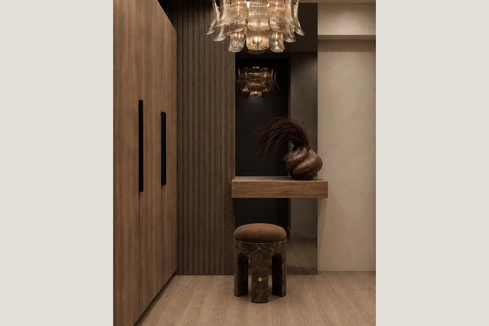 Entry with a fluted walnut wall, a floating console and a glass petal chandelier in a Brooklyn waterfront tower.