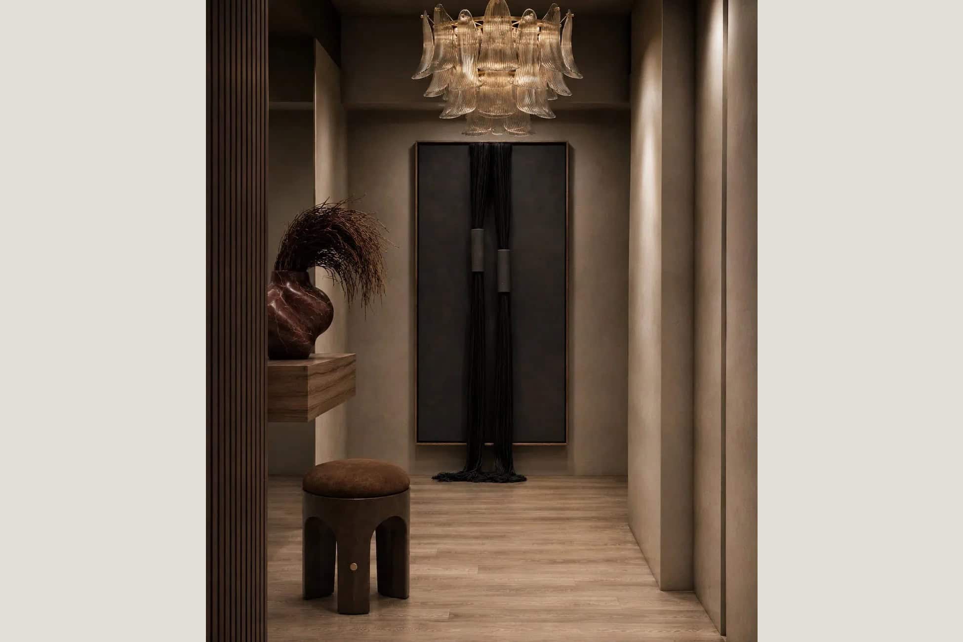 Entry hall with a glass petal chandelier, a fluted wood screen and a black fiber artwork in a Brooklyn tower.